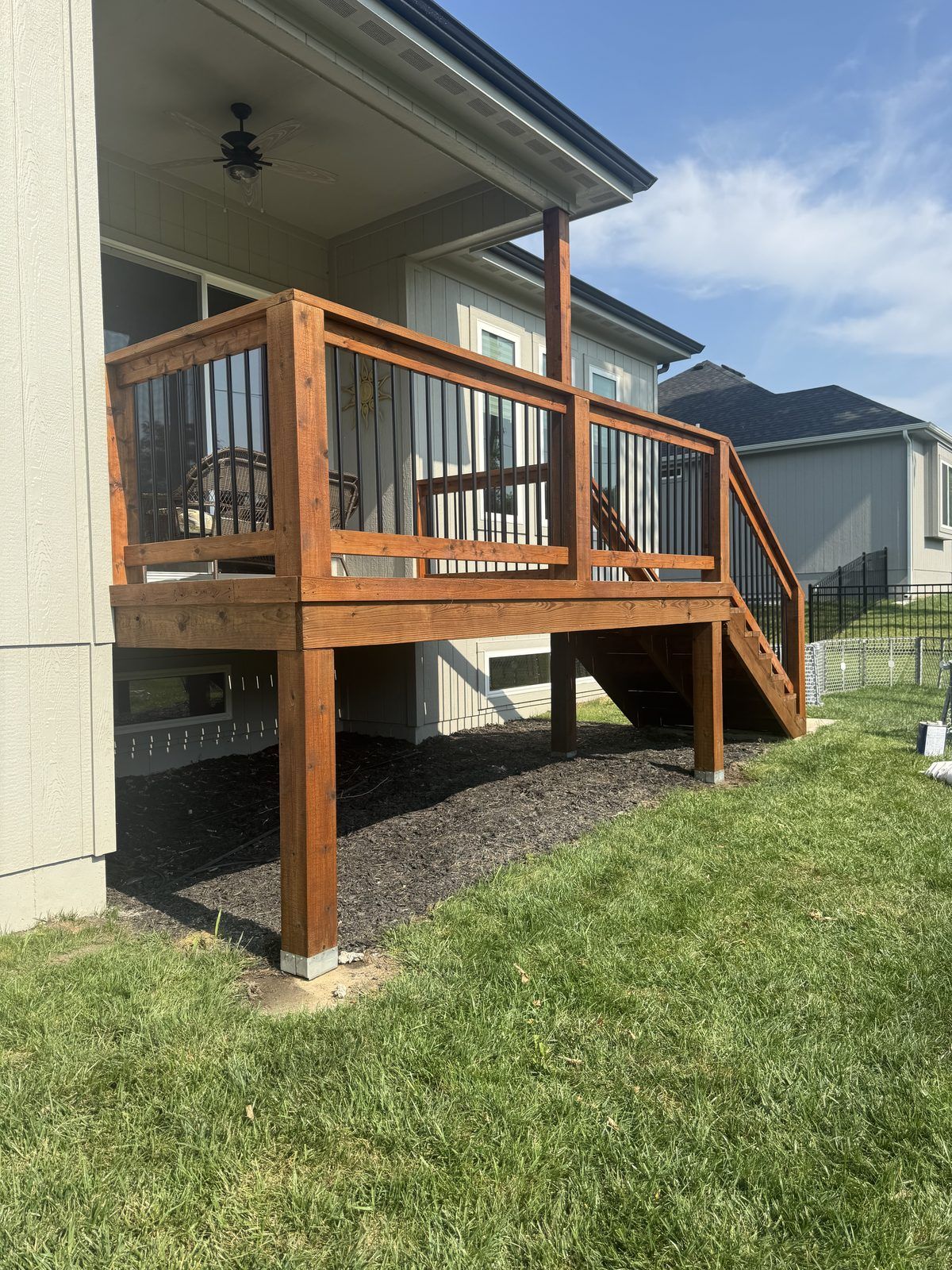 Elevated deck with black metal balusters, decks staining in Kansas City by Staining Grain
